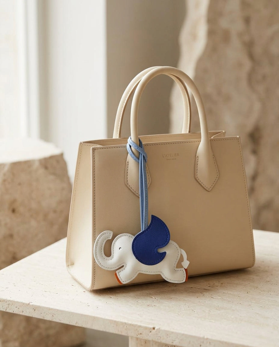 The Elephant Charm in white and navy on a cream leather tote